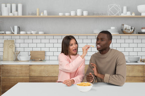 A man and a woman sitting at a table eating food