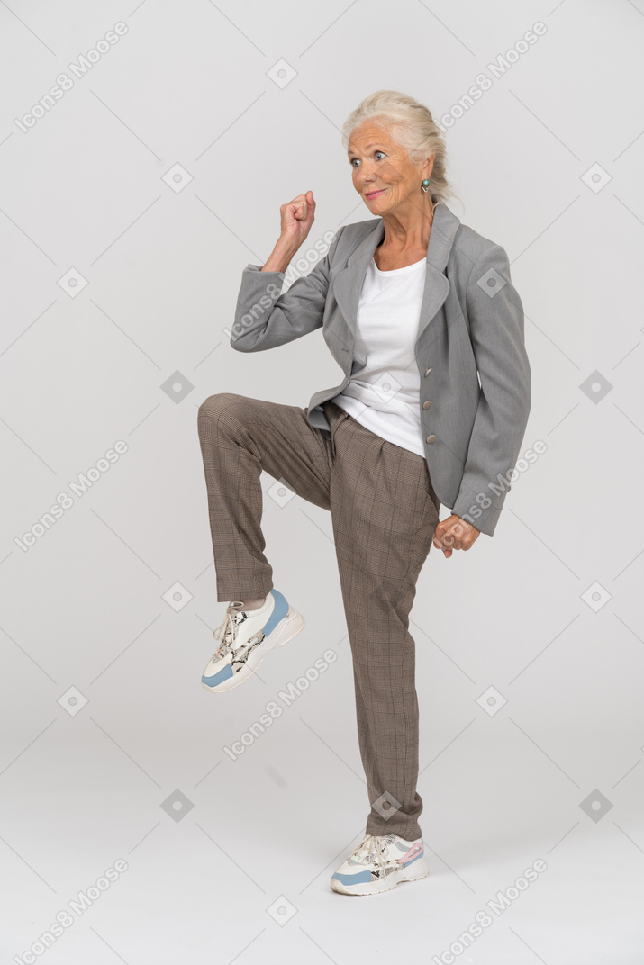 Vista lateral de uma senhora idosa de terno marchando