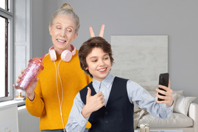 Um menino tirando selfie com a avó