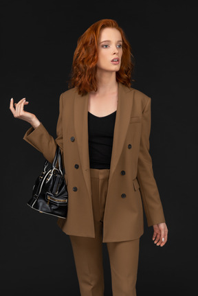 Young woman in a brown suit looking stunned