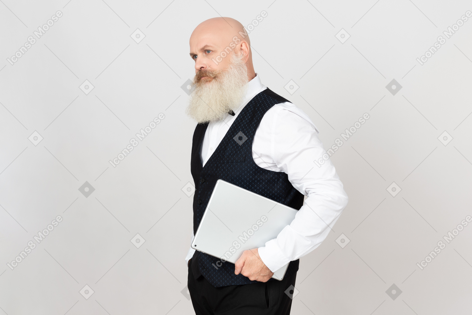 Пожилой мужчина держит планшет и стоит в профиле