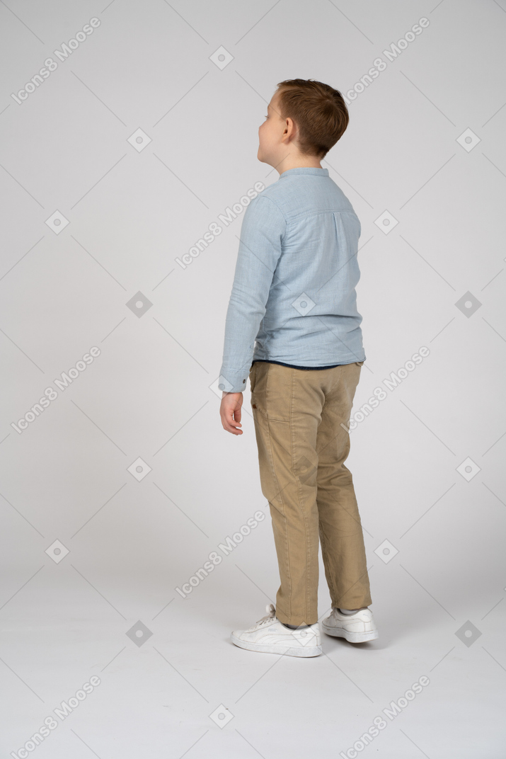 Vista lateral de un niño mirando hacia arriba