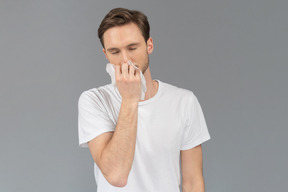 Front view of a young man smelling facial mask
