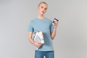 Süßer junger androgyner typ in einem hellblauen t-shirt und blue jeans, auf dem weg zum college