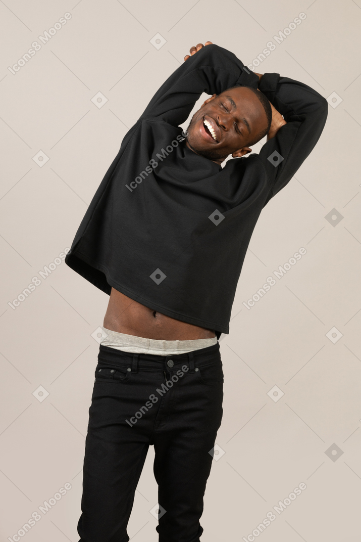Relaxed black man with hands folded behind back