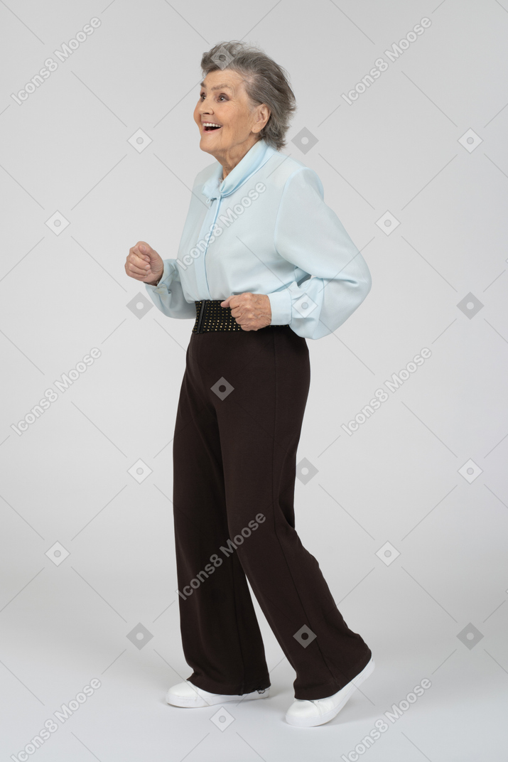 Three-quarter view of an old woman dancing excitedly