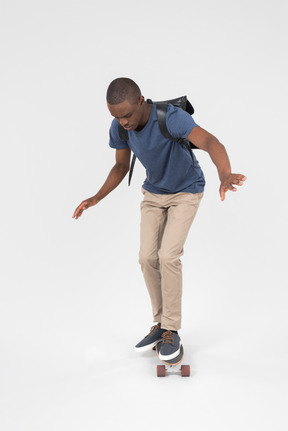 Black male tourist standing on skateboard