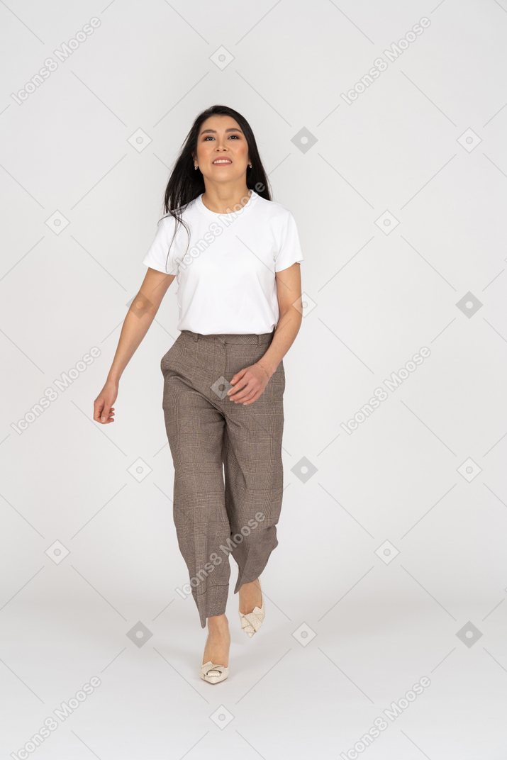 Front view of a running young lady in breeches and t-shirt