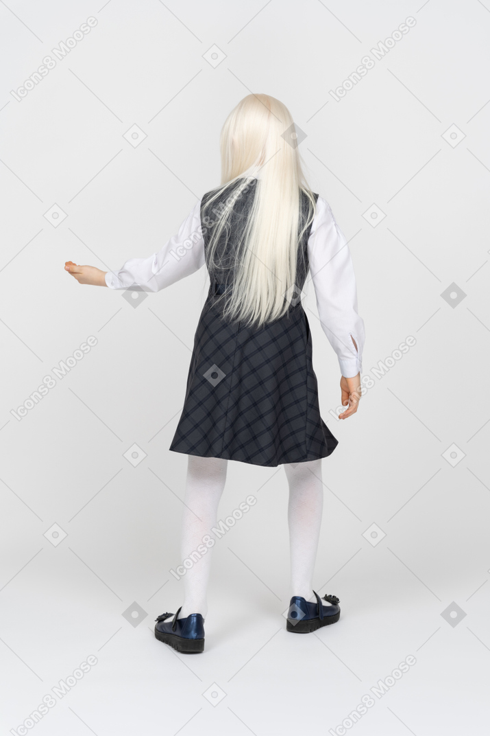 Back view of a schoolgirl holding out her hand