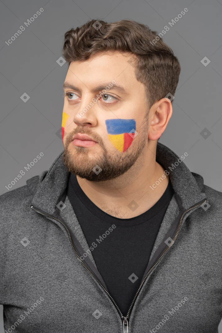 Vista frontal de un fanático del fútbol masculino con coloridos rostros art