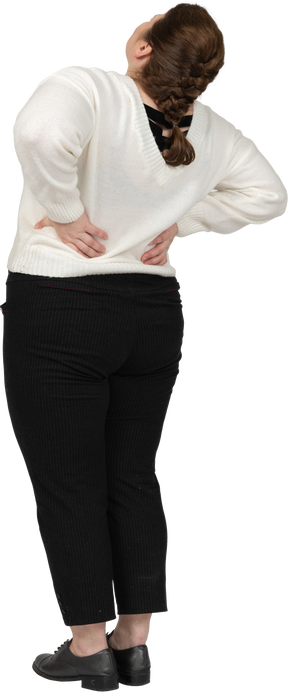 Taglie forti donna in maglione bianco che soffre di dolore nella parte bassa della schiena
