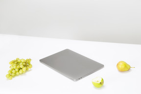 Macbook, ramo de uvas e peras