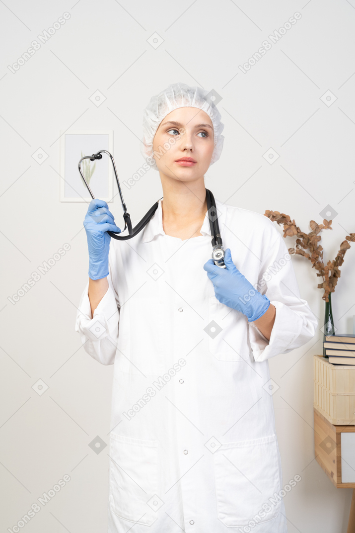 Front view of a young female doctor holding stethoscope