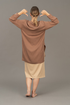 Back side of a woman with thumbs down pointing at her back