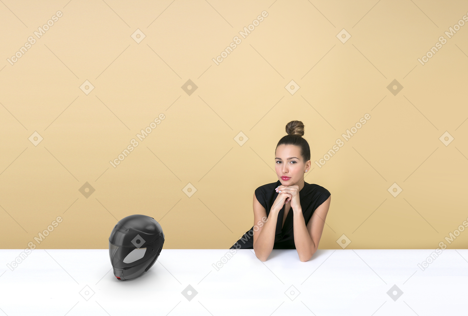 Young woman sitting at a table near a moto helmet