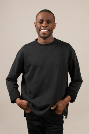 Smiling young man with hands in pockets