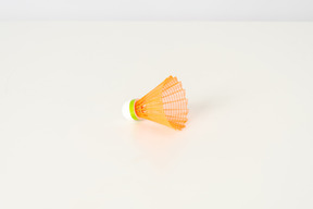 Orange shuttlecock on a white backgroud