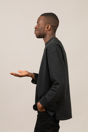 Side view of a man holding out his hand