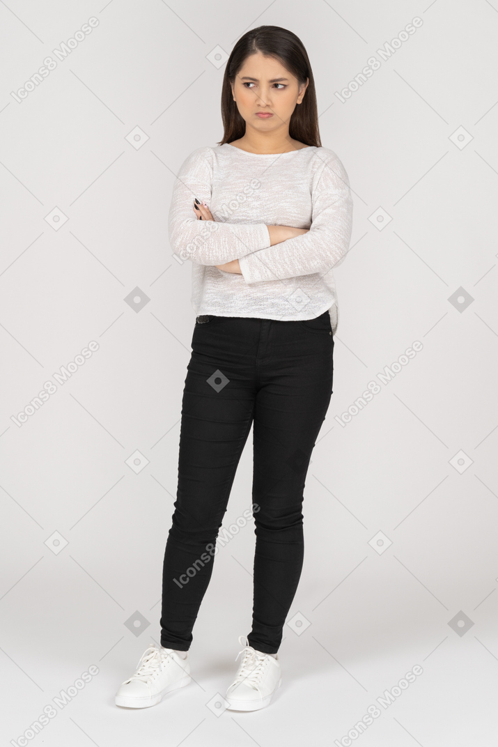 Front view of an offended young indian female in casual clothes crossing arms