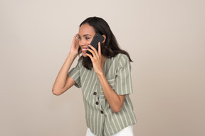 Smiling girl talking on the phone  and adjusting her hair