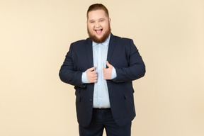 Young overweight man in suit showing ok sign