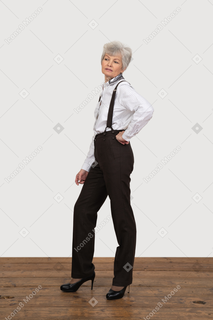 Vista lateral de una anciana egoísta en ropa de oficina