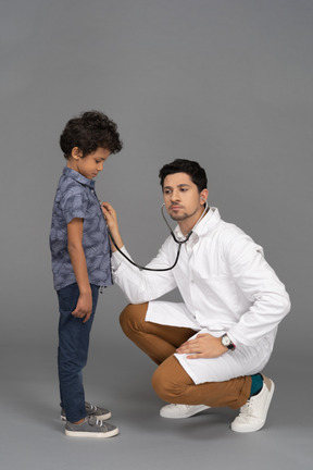 Doctor examining little boy