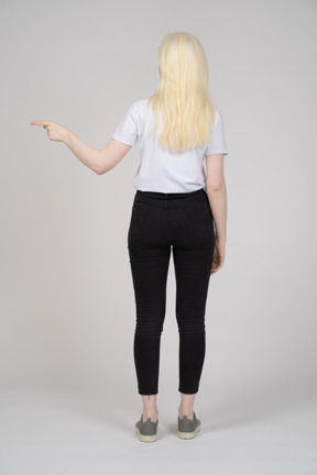 Back view of a young girl pointing left