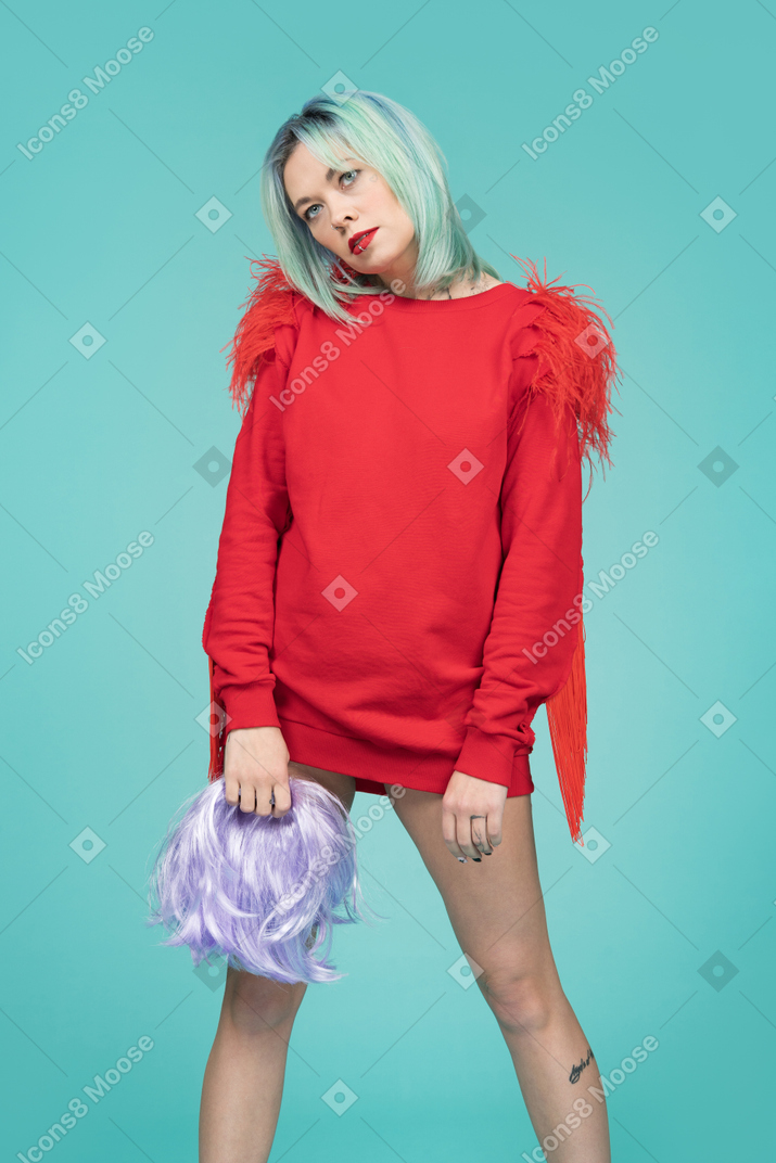 Jeune femme tenant une perruque violette