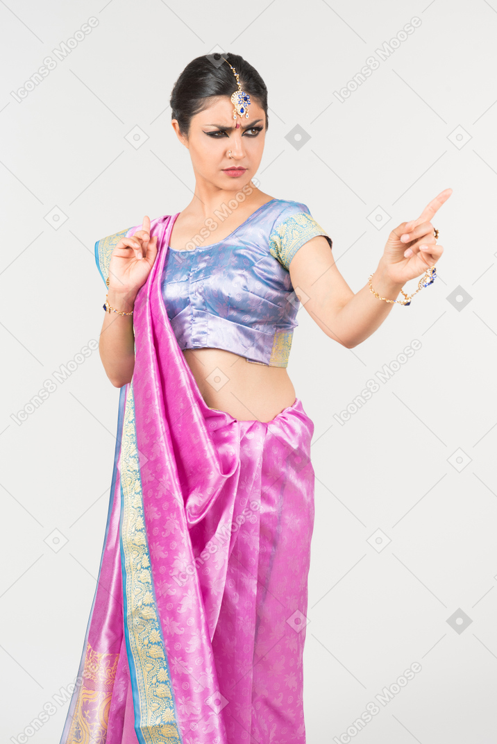 Mad looking young indian woman poiinting up