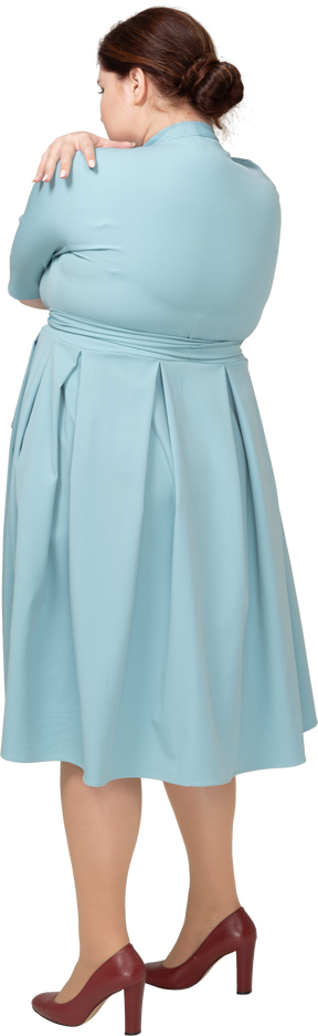 Vista posteriore di una donna in abito blu che si abbraccia