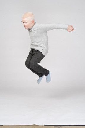 Three-quarter view of a boy jumping high