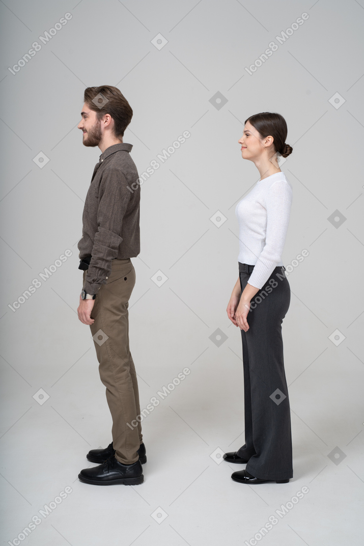 Side view of a pleased young couple in office clothing