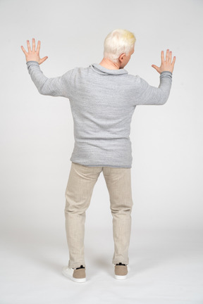 Vista traseira do homem mostrando o sinal de stop com ambas as mãos