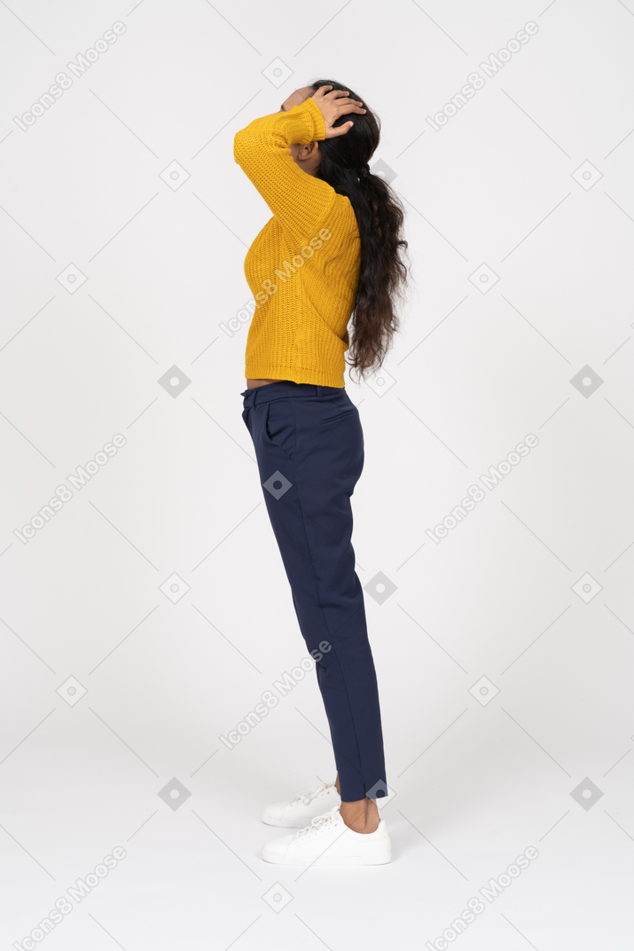 Side view of a girl in casual clothes standing with hands on head