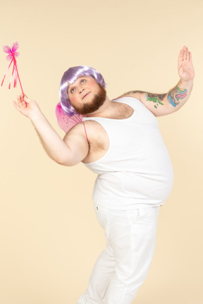 Dreamy young overweight man dressed as a fairy