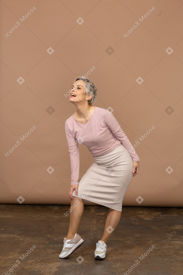 Vue de face d'une femme en vêtements décontractés touchant son genou