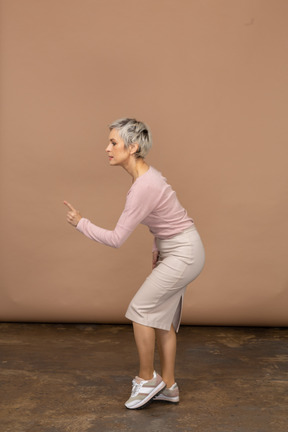 Vista lateral de uma mulher com roupas casuais mostrando um gesto de aviso