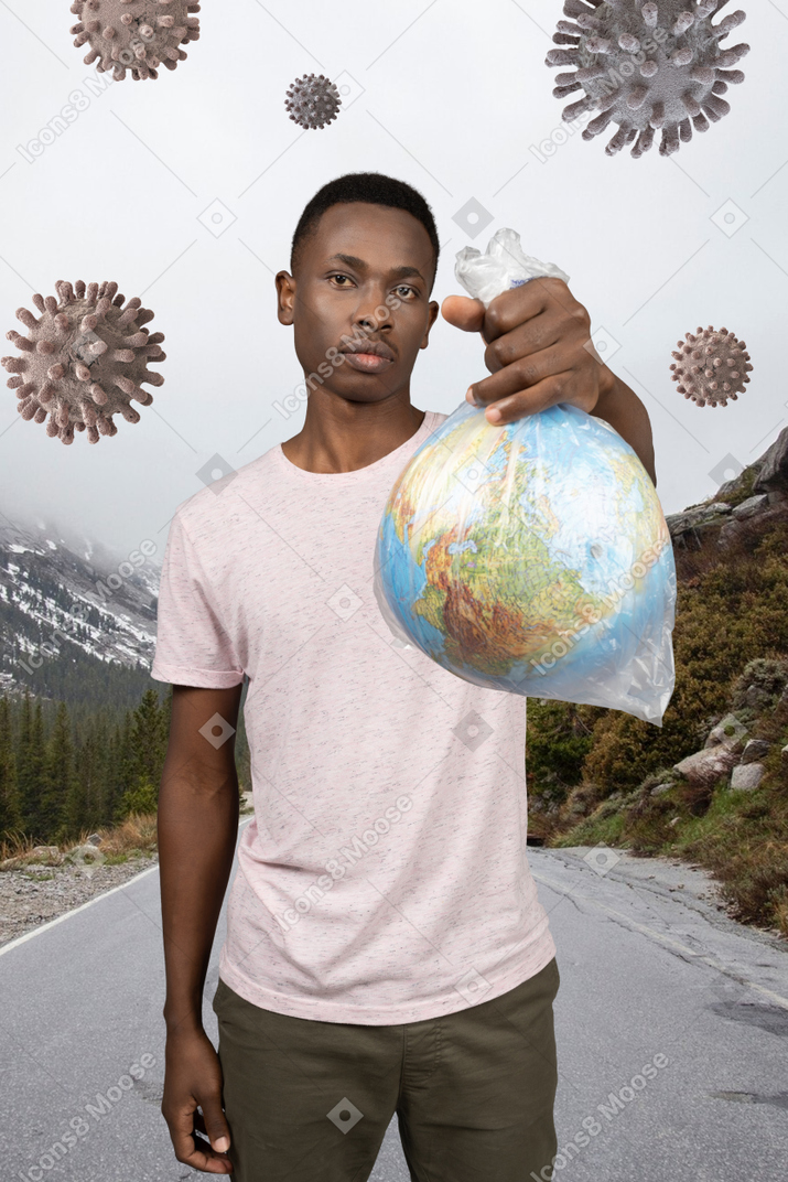 A man holding a plastic bag with a globe in it