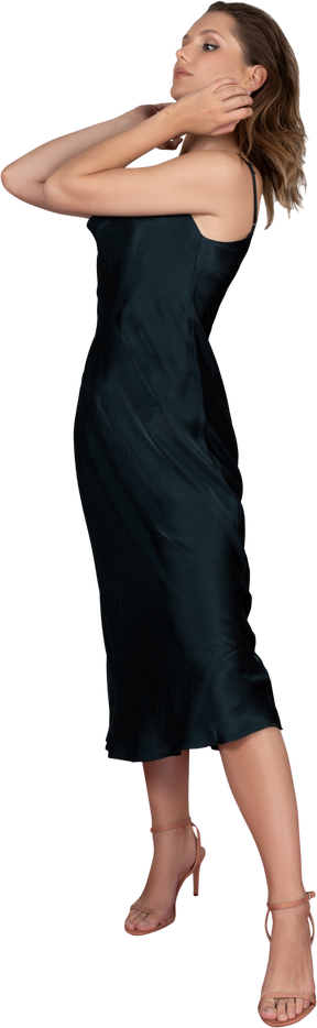 Трехчетвертный вид молодой женщины в ночном платье, позирующей на красной ковровой дорожке