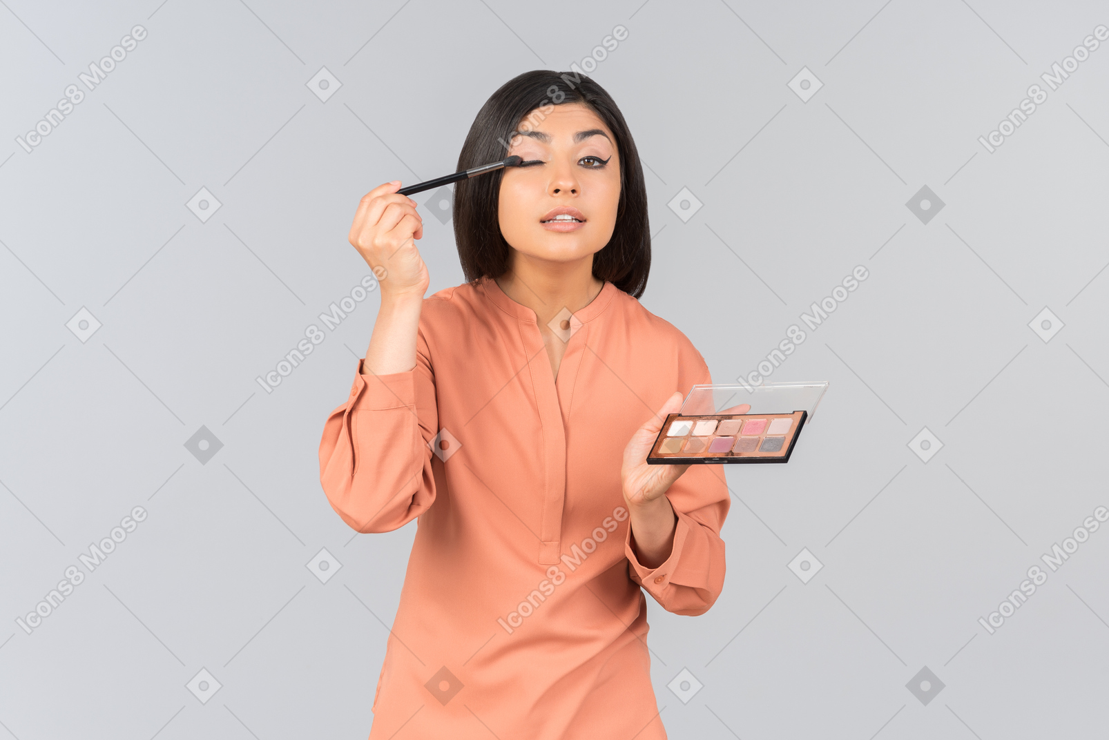 Indian woman pointing at lip balms she's holding