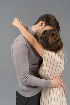 Couple kissing with arms around each other