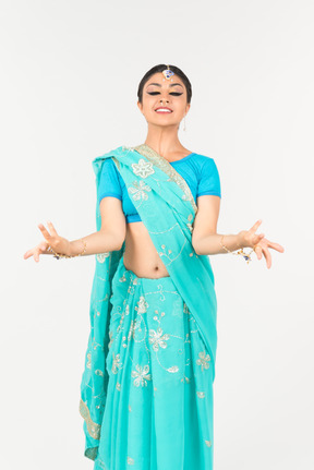 Jeune femme indienne en sari bleu debout en position de danse