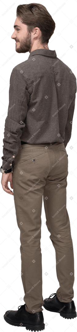 Three-quarter back view of a pleased young man in office clothing