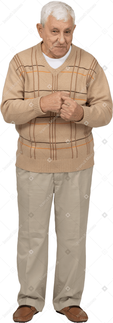 Vista frontal de un anciano feliz con ropa informal de pie con los puños apretados