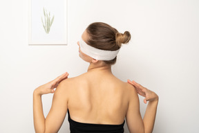 Mujer con vendaje sobre los ojos tocando los hombros