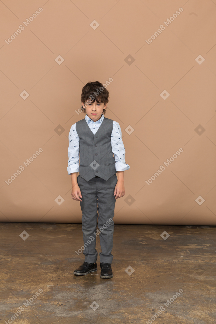 静止している灰色のスーツを着た少年の正面図