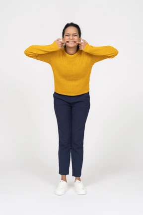 Front view of a girl in casual clothes putting fingers in her mouth