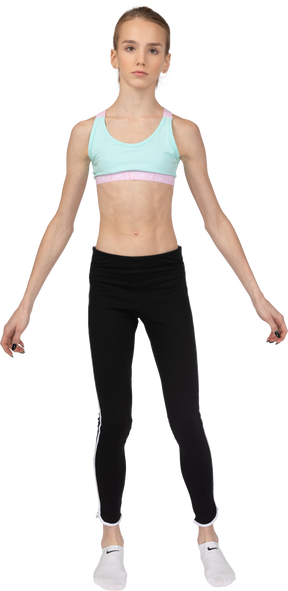 Front view of a teen girl in sportswear looking straight and outspreading hands