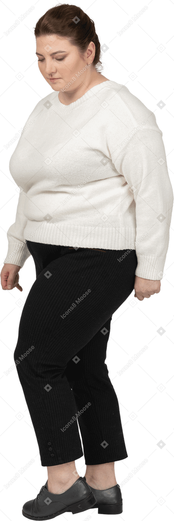 Donna grassoccia in maglione bianco che guarda in basso
